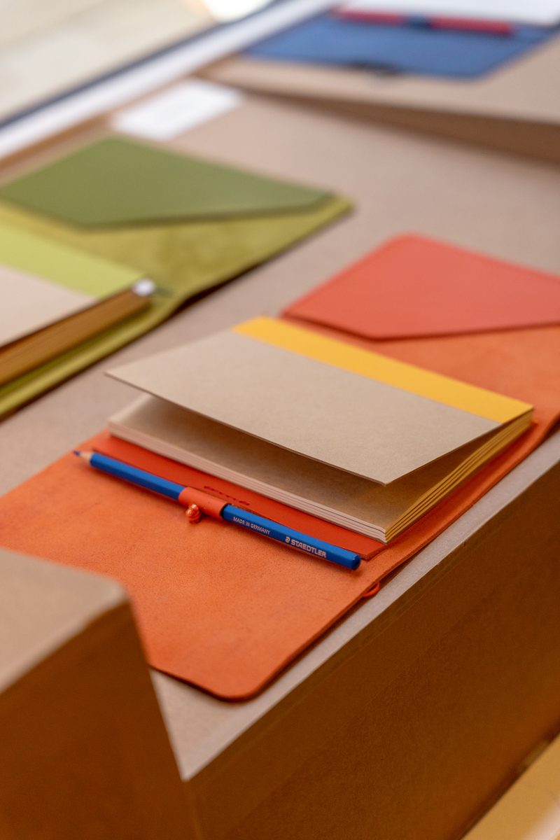 Carnet cuir orange ouvert, avec son crayon